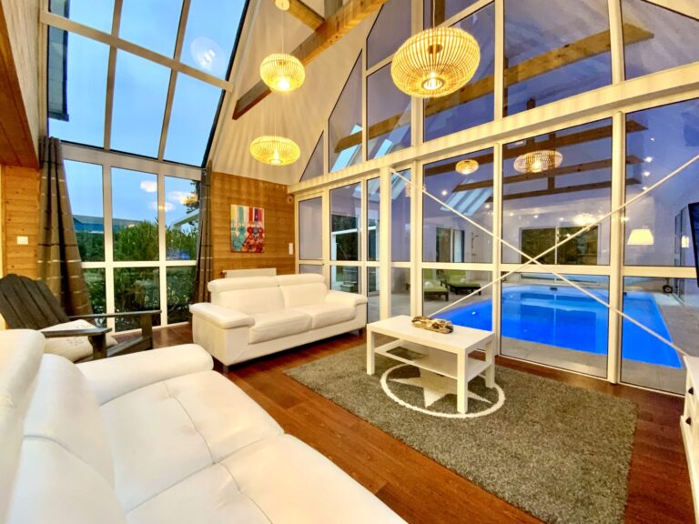 Grand salon avec baie donnant sur la piscine chauffée